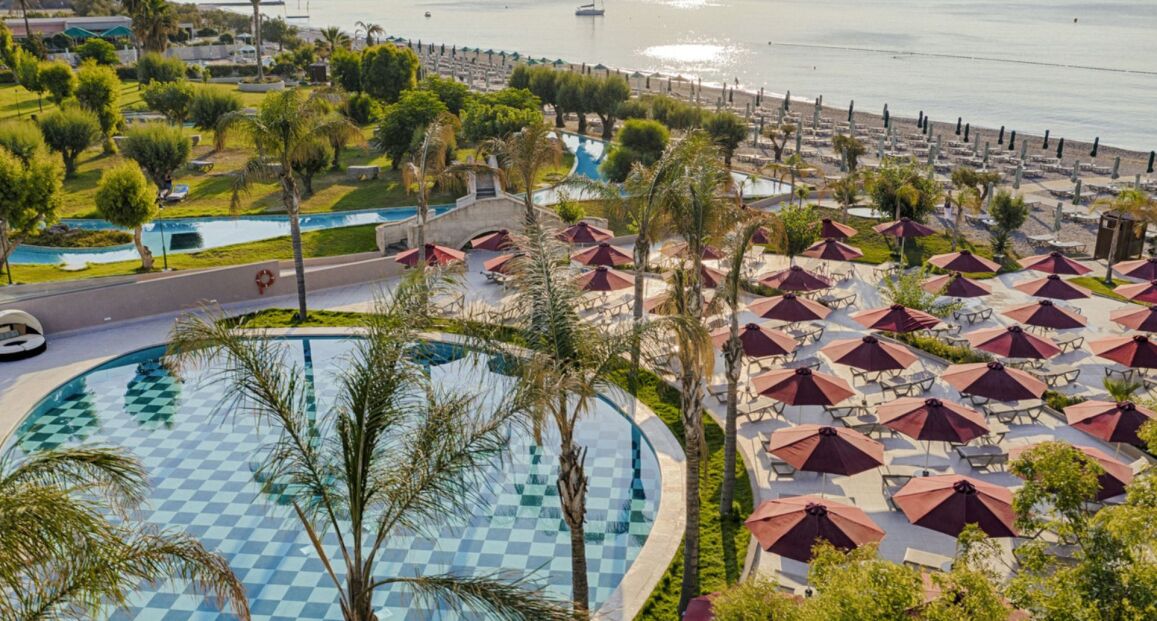 Hotel Esperos Palace u oblázkové pláže na Rhodosu.